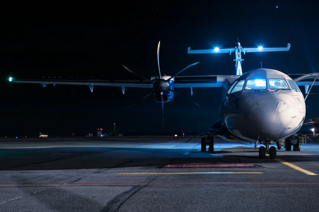 Aircraft on a dimly lit runway highlighting aerospace telemetry data systems.